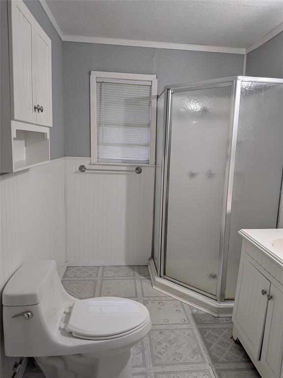 2009 County Road 4619 Athens, TX 75752 - Photo 27 of 36 Bathroom with vanity, a stall shower, ornamental molding, a wainscoted wall, and a textured ceiling