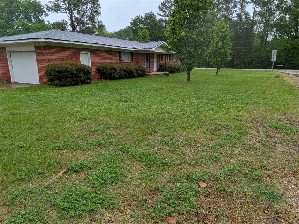 2009 County Road 4619 Athens, TX 75752 - Photo 4 of 36 View of front of house featuring a garage, brick siding, and a front lawn