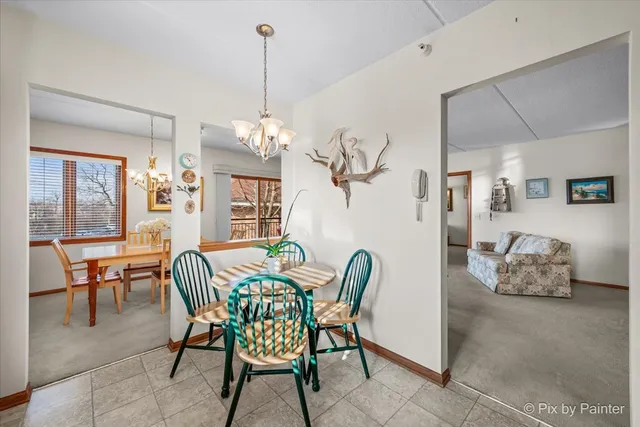 a dining room with furniture a chandelier and wooden floor