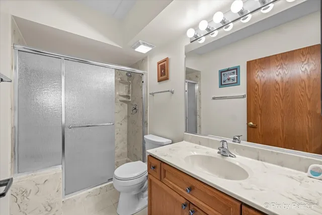 a bathroom with a granite countertop sink toilet and shower