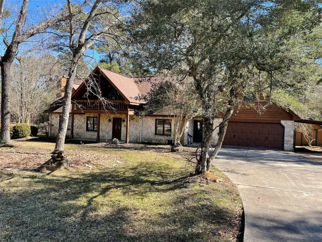 a tree in front of a house with a yard