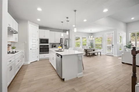 a large kitchen with stainless steel appliances lots of counter space and windows