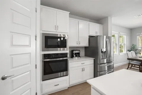 a kitchen with white cabinets and stainless steel appliances