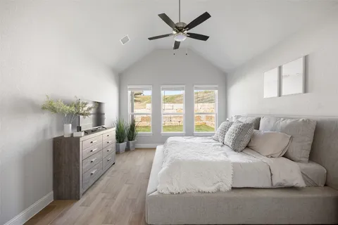 a spacious bedroom with a large bed and a chandelier