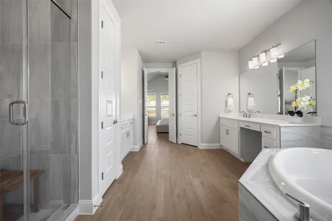 a spacious bathroom with a double vanity sink a mirror and a shower