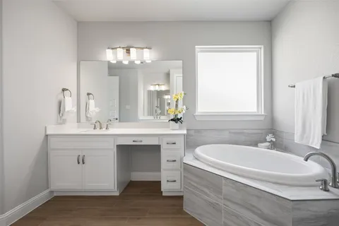 a bathroom with a tub sink and mirror