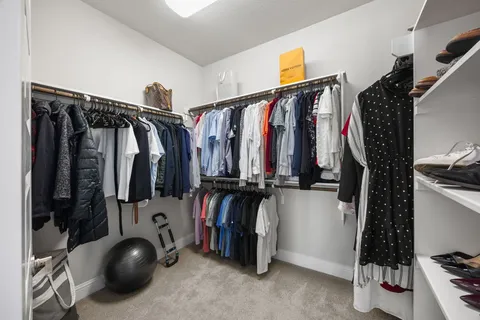 a view of walk in closet with clothes and shoes