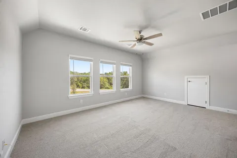 an empty room with a ceiling fan and window