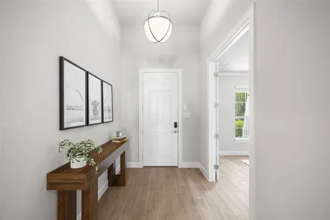 a view of a hallway with entryway wooden floor and front door