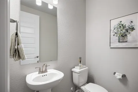 a bathroom with a toilet sink and mirror