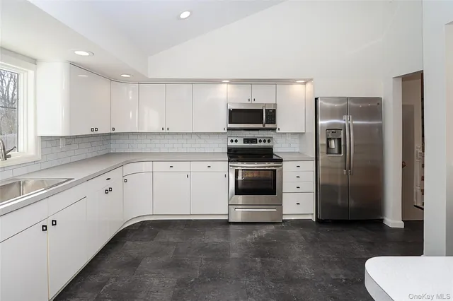 a kitchen with stainless steel appliances a refrigerator sink and stove
