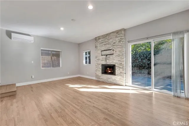an empty room with windows and fireplace