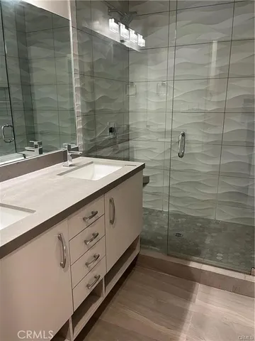 a bathroom with a double vanity sink and a shower