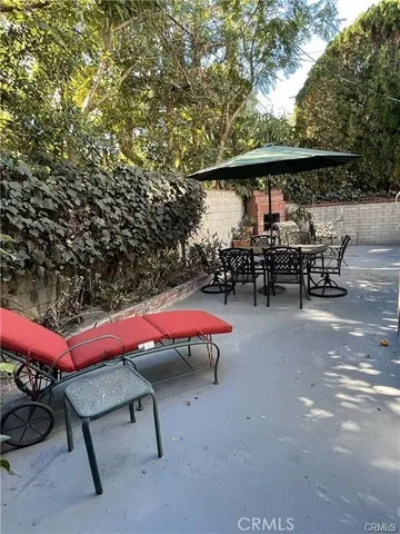 a large kitchen with granite countertop a refrigerator oven a sink dishwasher and white cabinets with wooden floor