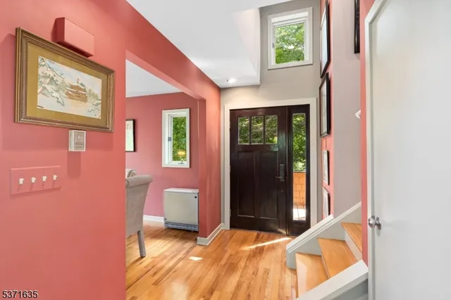 a view of a hallway with a bedroom and wooden floor
