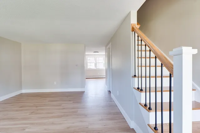 a view of a hallway with wooden floor and windows