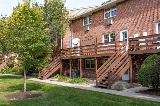 a view of a house with a small yard and potted plants