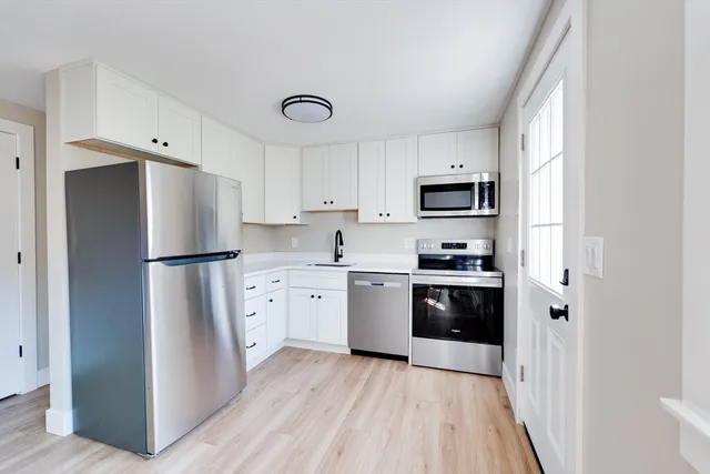 a kitchen with stainless steel appliances a refrigerator sink and microwave