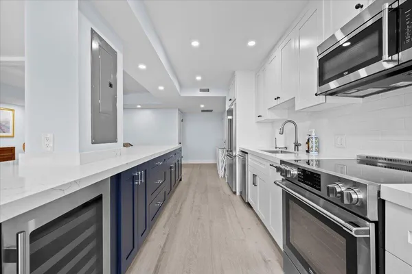 a large kitchen with a sink a window and stainless steel appliances