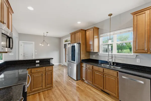 a kitchen with stainless steel appliances granite countertop a sink stove and refrigerator