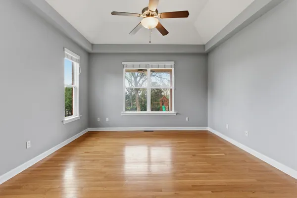 a view of an empty room with window and wooden floor
