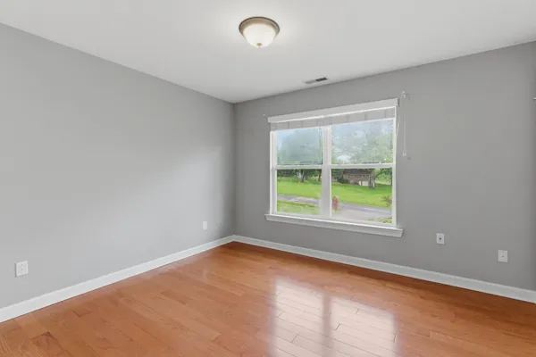 a view of an empty room with wooden floor