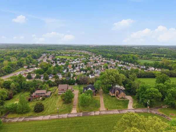 an aerial view of residential houses with outdoor space and trees