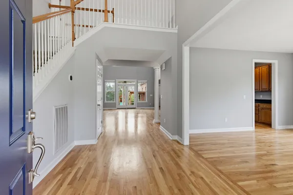 a view of a hallway with wooden floor and staircase