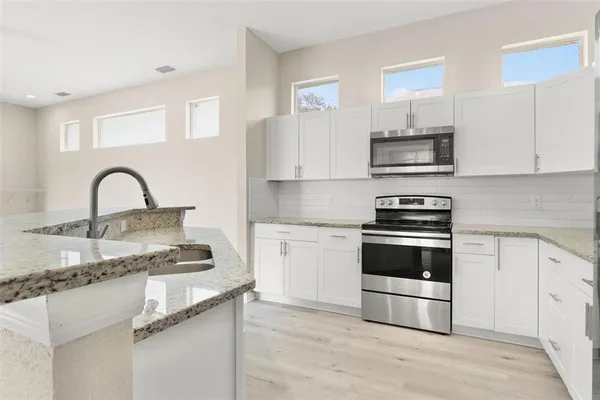 a kitchen with stainless steel appliances a sink and a stove
