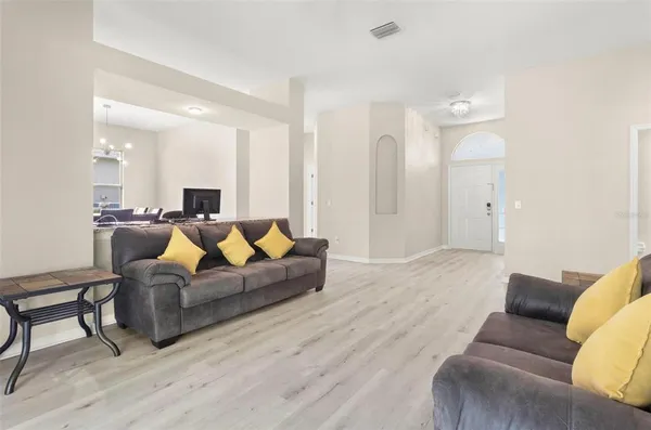 a living room with furniture and a wooden floor