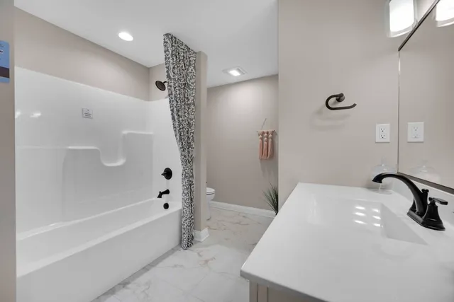 a bedroom with a large bed chandelier and a window