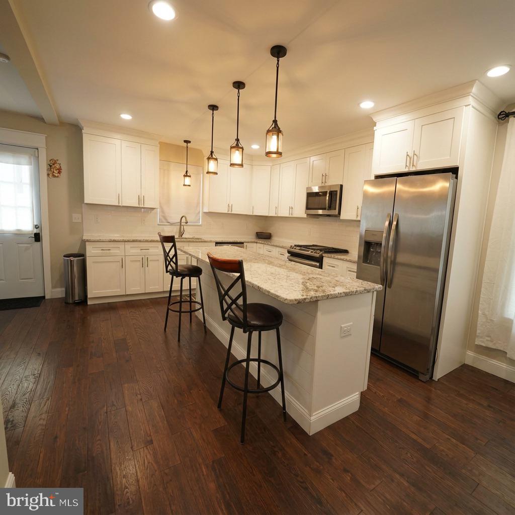 10 West Monroe Street Mount Holly, NJ 08060 - Photo 5 of 16 a kitchen with stainless steel appliances a dining table chairs stove refrigerator and cabinets