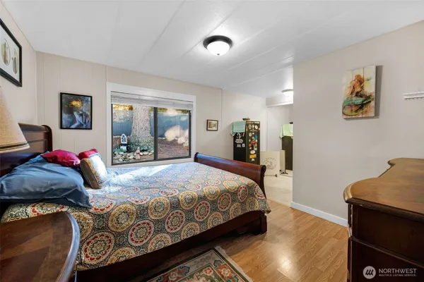 a bedroom with a bed and wooden floor