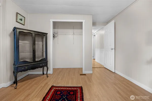 a view of a hallway with wooden floor and furniture