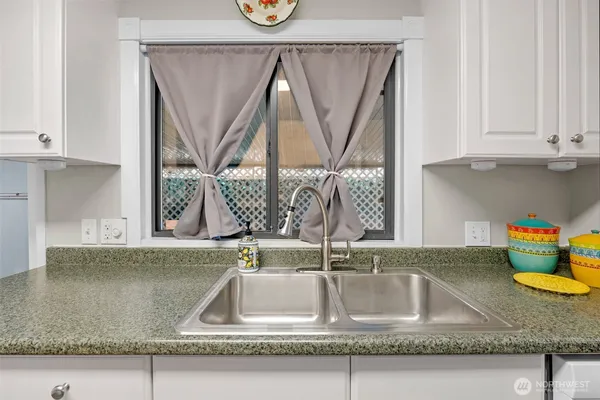 a kitchen with granite countertop a sink and a wooden cabinets