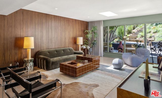 a living room with furniture and a floor to ceiling window