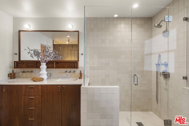 a bathroom with a double vanity sink mirror and shower