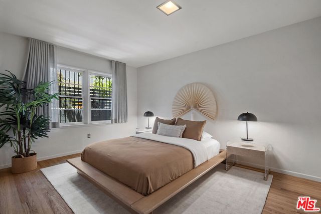 a bedroom with bed and a large window