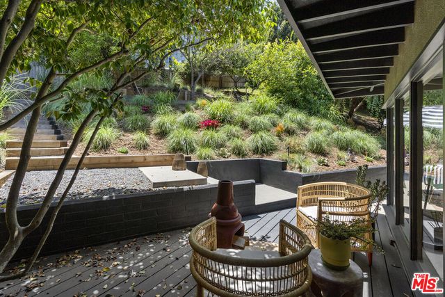 a view of a porch with furniture and garden