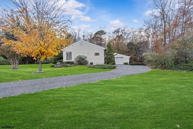a front view of a house with a yard and trees