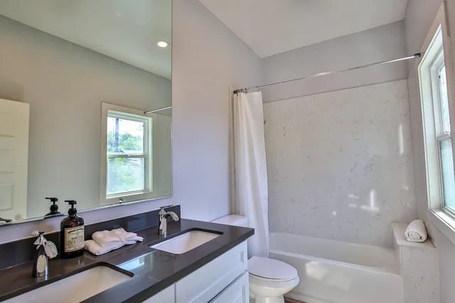 a bathroom with a granite countertop sink toilet and shower