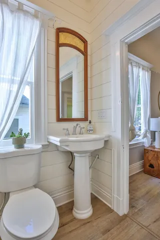 a bathroom with a toilet sink and mirror