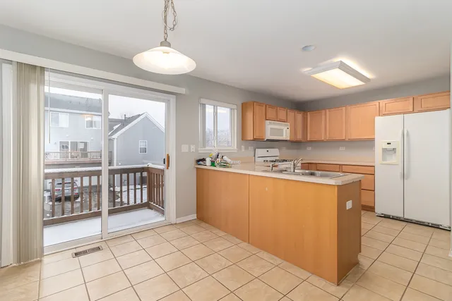 a kitchen with stainless steel appliances granite countertop a refrigerator a sink and a stove