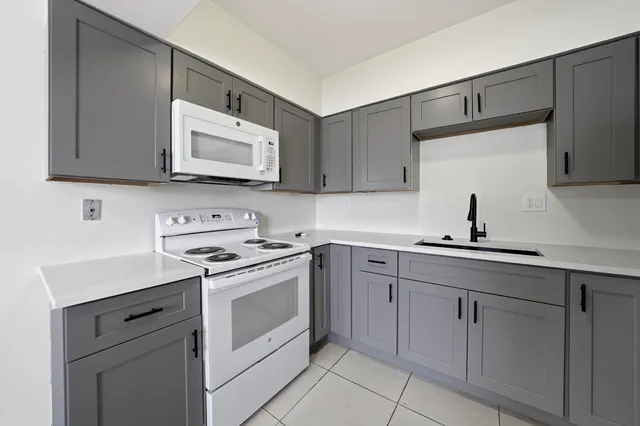 a kitchen with white cabinets and a stove top oven