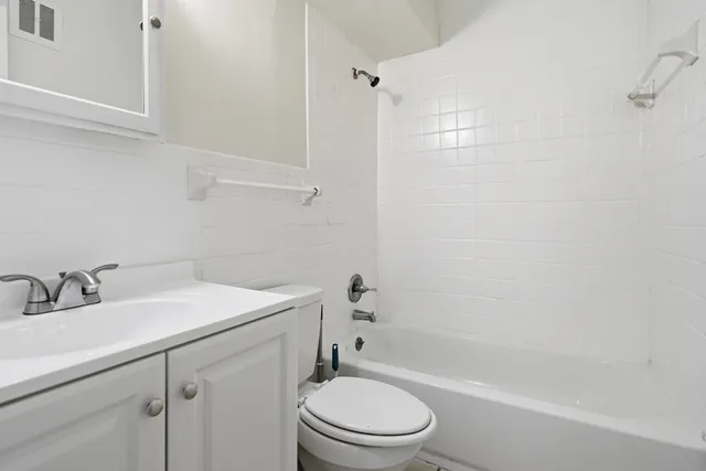 a bathroom with a sink toilet vanity and shower