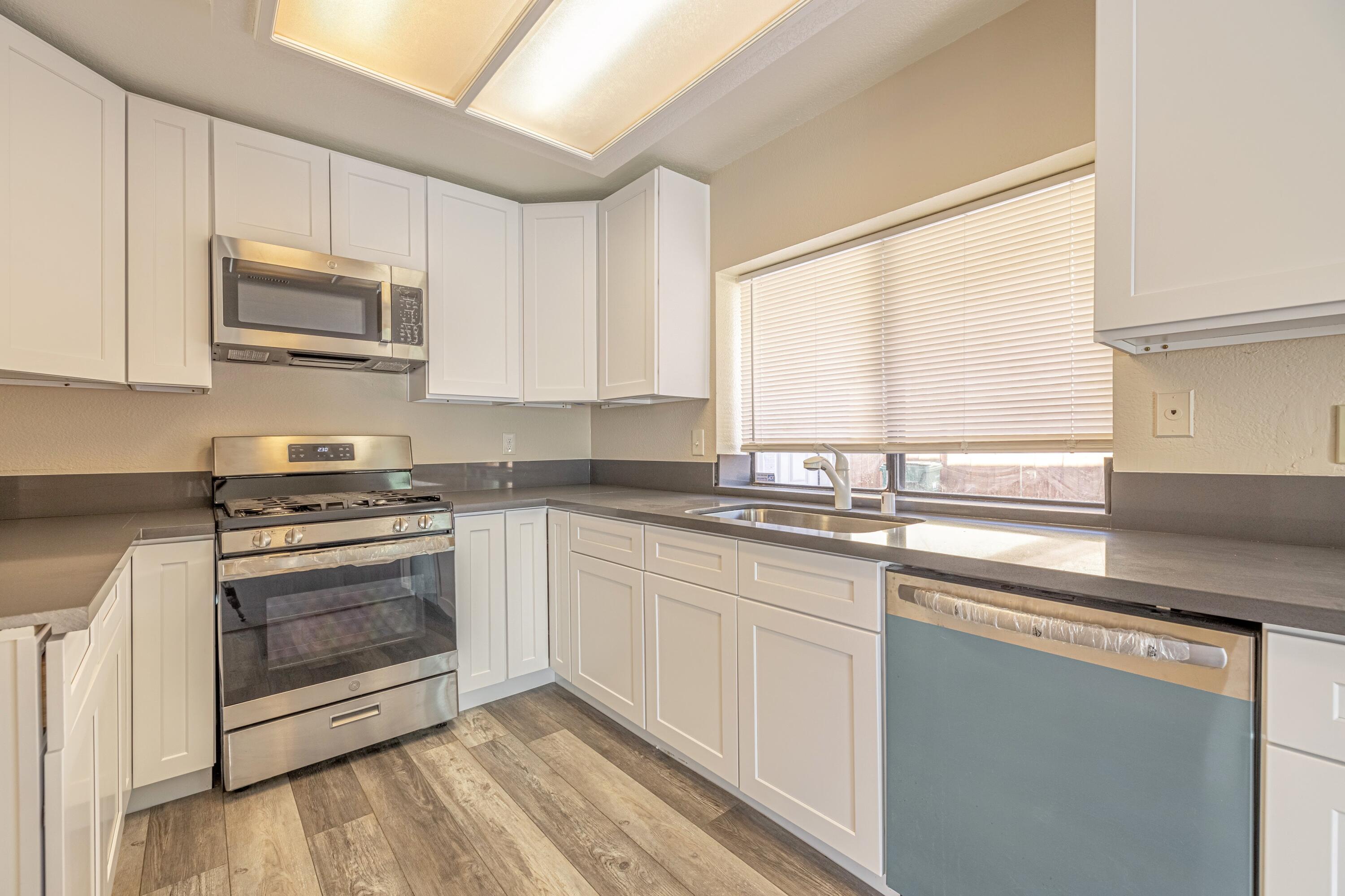 533 East Jackman Street Lancaster, CA 93535 - Photo 12 of 31 a kitchen with stainless steel appliances granite countertop a sink a stove and a microwave