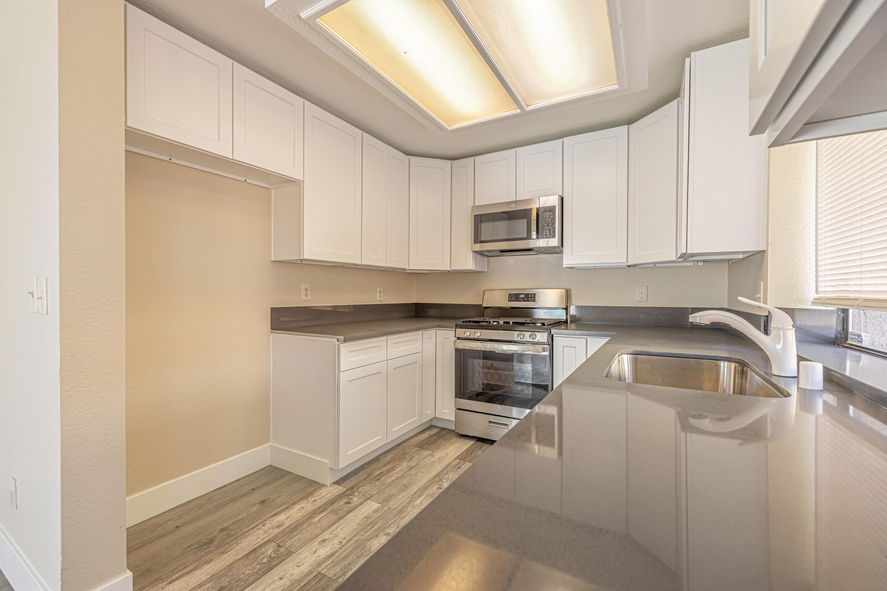 533 East Jackman Street Lancaster, CA 93535 - Photo 13 of 31 a kitchen with granite countertop a sink cabinets and stainless steel appliances
