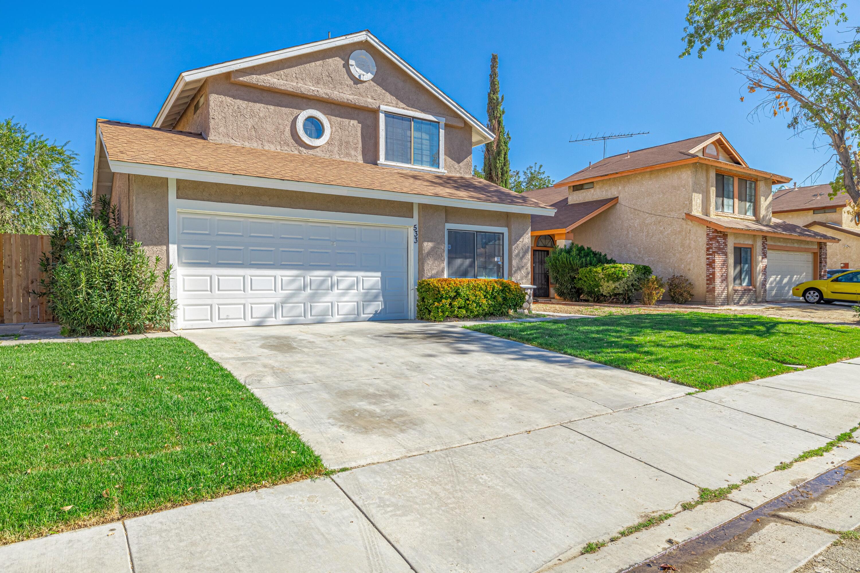 533 East Jackman Street Lancaster, CA 93535 - Photo 3 of 31 a front view of a house with a yard and garage