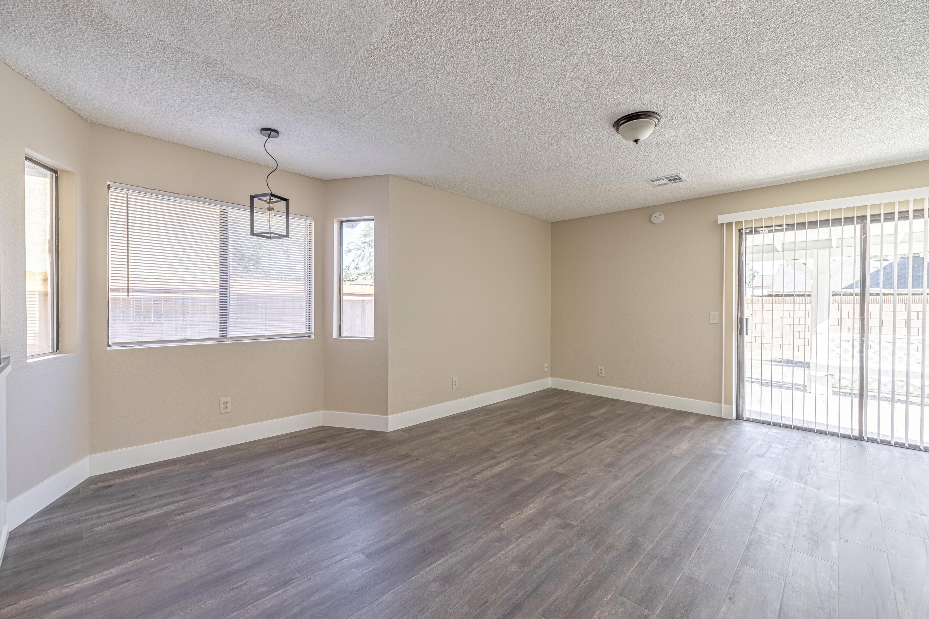 533 East Jackman Street Lancaster, CA 93535 - Photo 9 of 31 an empty room with wooden floor and windows