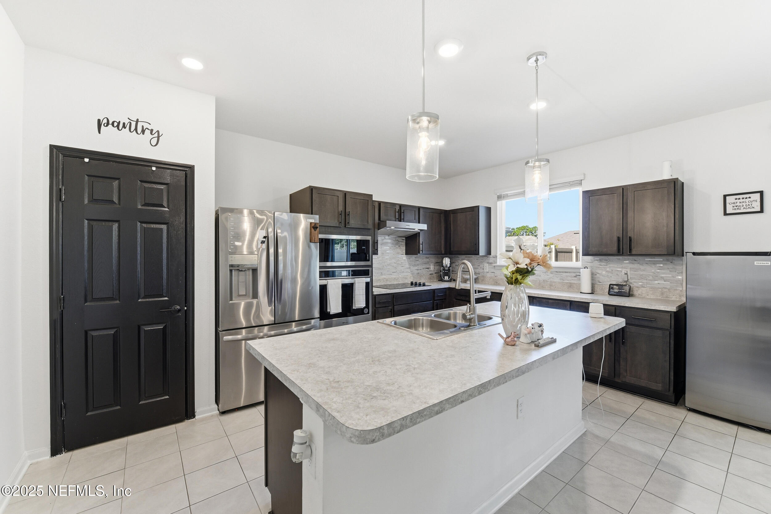 11183 Stapleton Drive Jacksonville, FL 32222 - Photo 8 of 43 a kitchen with stainless steel appliances kitchen island granite countertop a refrigerator a sink dishwasher and a stove with wooden floor